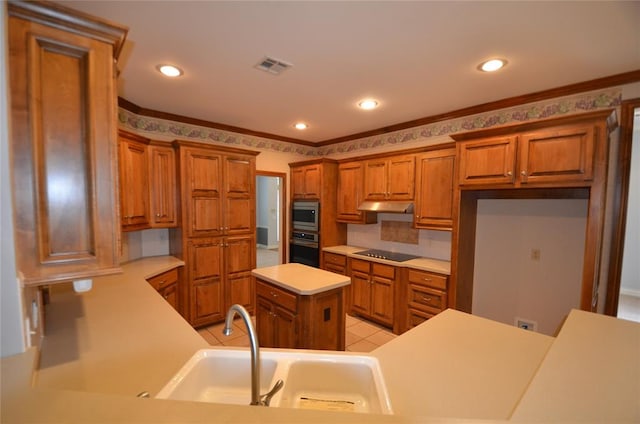 kitchen featuring a center island, sink, light tile patterned floors, ornamental molding, and appliances with stainless steel finishes