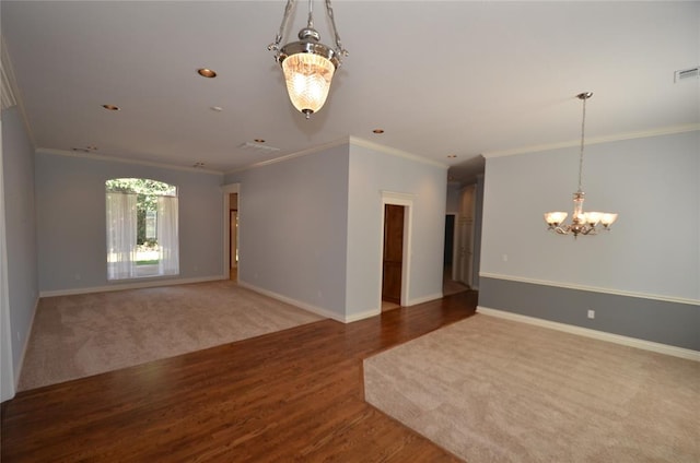 empty room with a chandelier, hardwood / wood-style floors, and ornamental molding