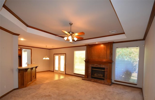 unfurnished living room with crown molding, light colored carpet, and a brick fireplace