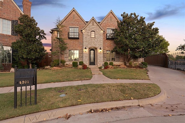 view of front of property with a yard and a balcony