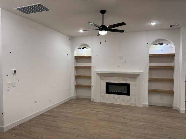 unfurnished living room with hardwood / wood-style flooring, a fireplace, and ceiling fan