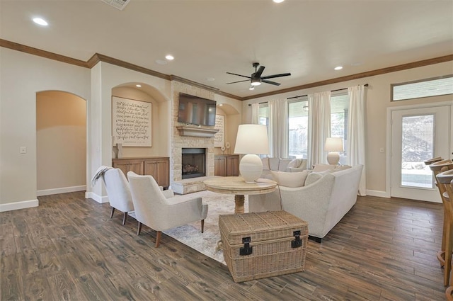 living area featuring dark wood-type flooring, a ceiling fan, recessed lighting, a stone fireplace, and baseboards