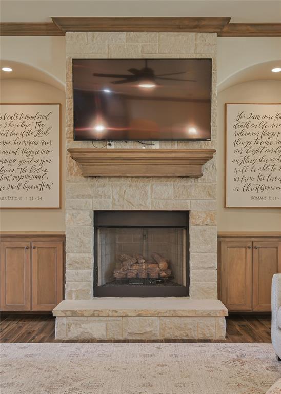 interior details featuring ornamental molding, a fireplace, and wood finished floors