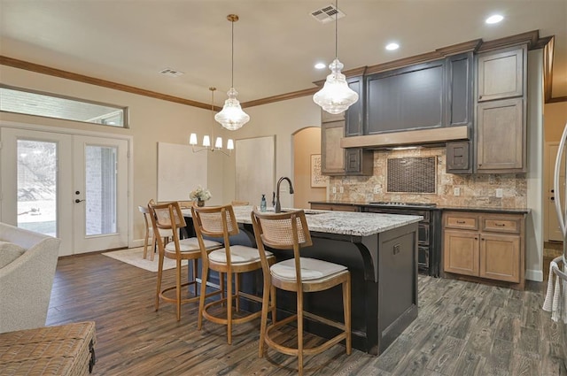 kitchen featuring arched walkways, visible vents, french doors, and ornamental molding