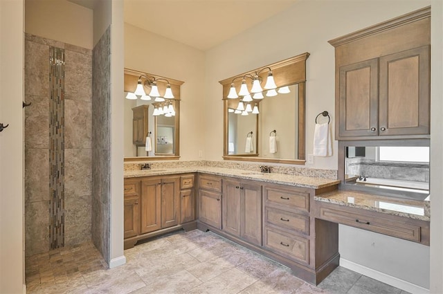 bathroom with double vanity, a tile shower, and a sink