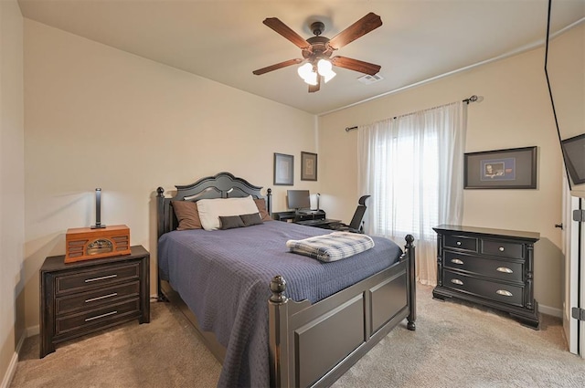 bedroom featuring baseboards, light colored carpet, visible vents, and ceiling fan