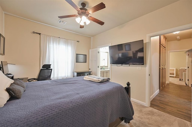 bedroom with visible vents, baseboards, ceiling fan, carpet flooring, and ensuite bath