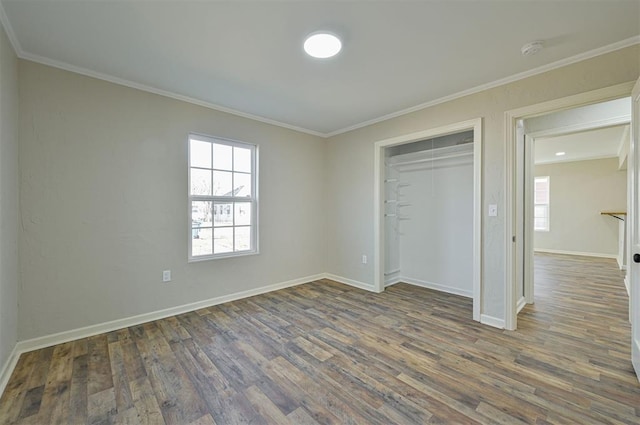 unfurnished bedroom with ornamental molding, dark hardwood / wood-style floors, and a closet