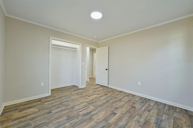 unfurnished bedroom with a closet, ornamental molding, and dark hardwood / wood-style floors