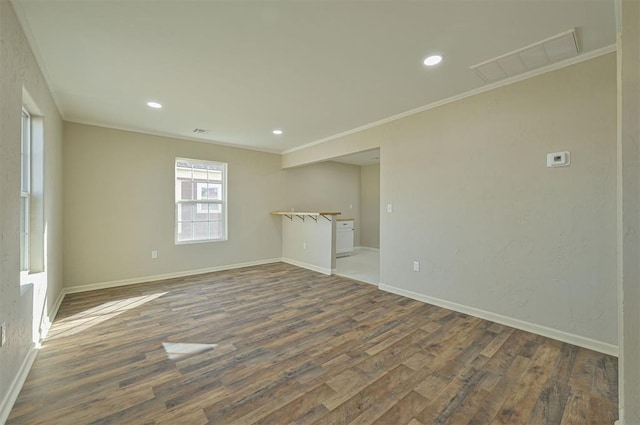 spare room featuring ornamental molding and dark hardwood / wood-style floors