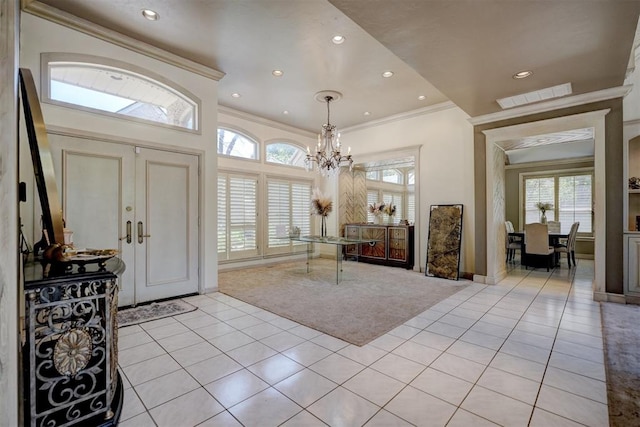 entrance foyer with plenty of natural light, light tile patterned flooring, and crown molding