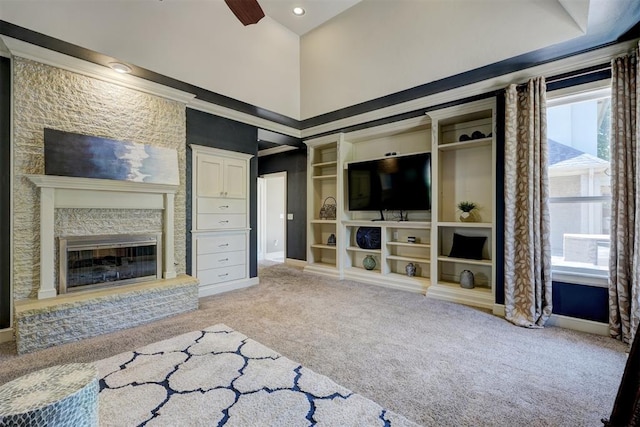 unfurnished living room with a high ceiling, light colored carpet, and ceiling fan