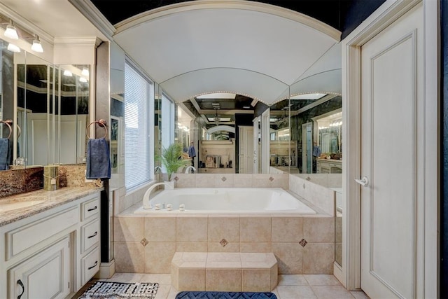 bathroom featuring vanity, a relaxing tiled tub, and tile patterned floors