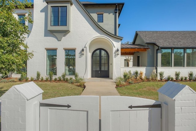 view of front facade with a front lawn and french doors