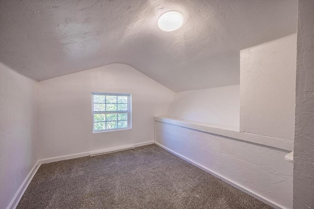 bonus room with a textured ceiling, carpet floors, and lofted ceiling