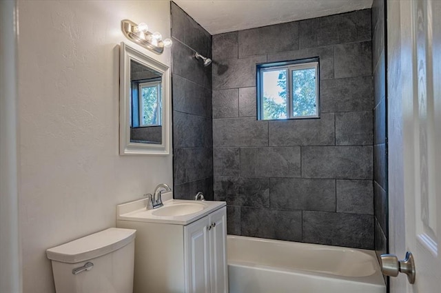 full bathroom with vanity, tiled shower / bath combo, and toilet