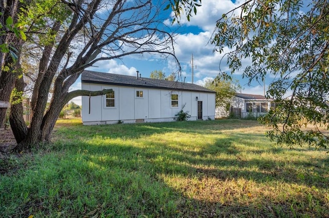 rear view of house featuring a lawn