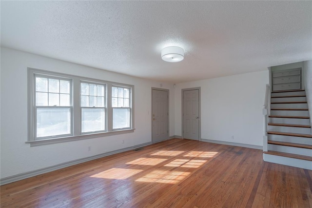 spare room with hardwood / wood-style floors and a textured ceiling