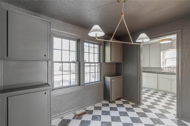 kitchen featuring white cabinetry, sink, and a textured ceiling