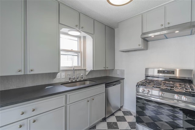 kitchen featuring appliances with stainless steel finishes, a textured ceiling, gray cabinets, and sink