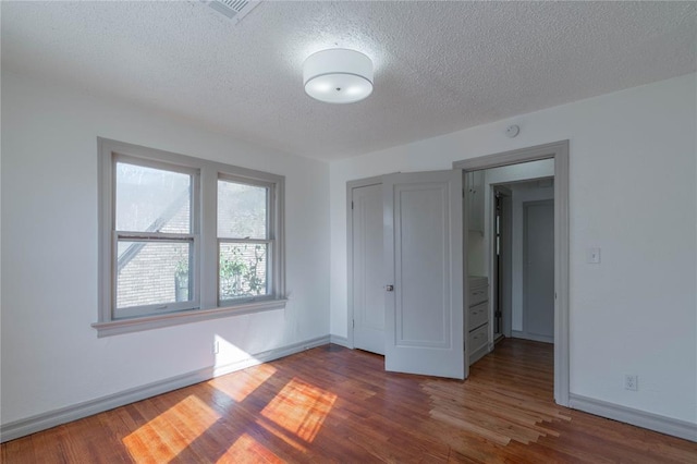 unfurnished bedroom with wood-type flooring and a textured ceiling