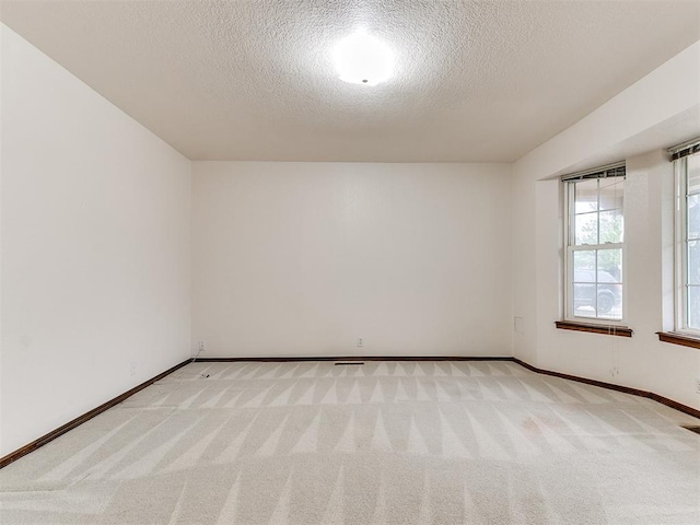 unfurnished room with light carpet and a textured ceiling