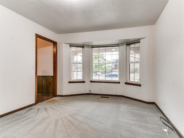 unfurnished room featuring carpet floors and a textured ceiling