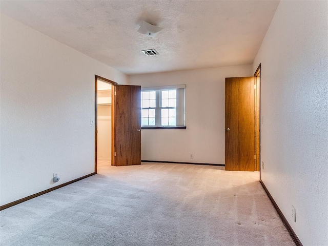 unfurnished bedroom with light carpet and a closet