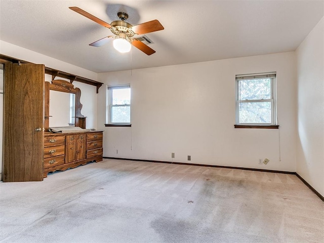 unfurnished bedroom featuring light carpet and ceiling fan