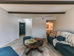 living room featuring hardwood / wood-style floors and beamed ceiling