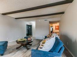 living room with beamed ceiling and wood-type flooring