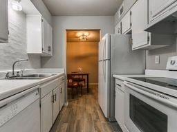 kitchen featuring white cabinetry, white appliances, dark hardwood / wood-style floors, and sink