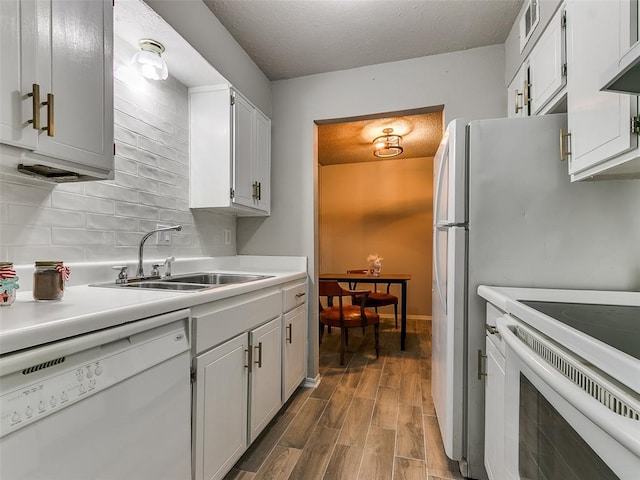 kitchen with extractor fan, white appliances, wood finished floors, a sink, and light countertops