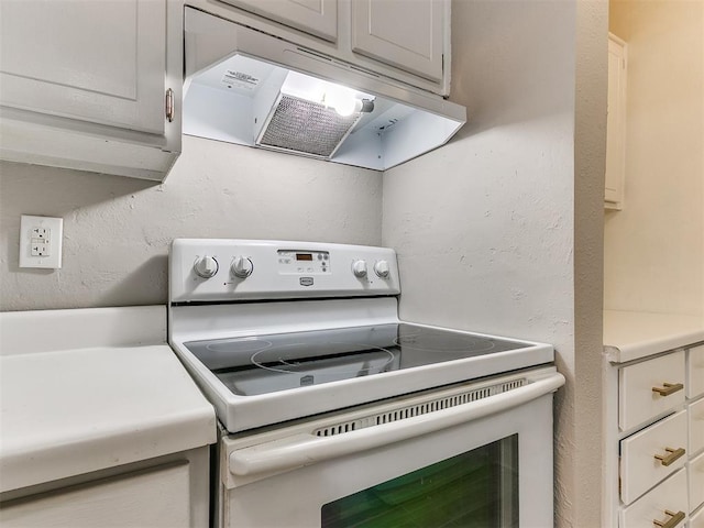 kitchen with white electric stove, light countertops, a textured wall, and range hood