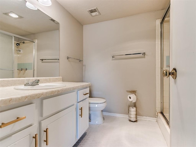 bathroom featuring toilet, a shower with door, visible vents, and vanity