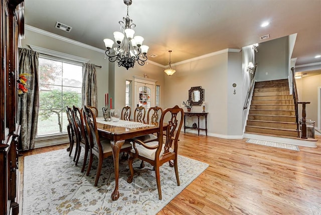 dining area with stairway, a notable chandelier, light wood-style flooring, and visible vents