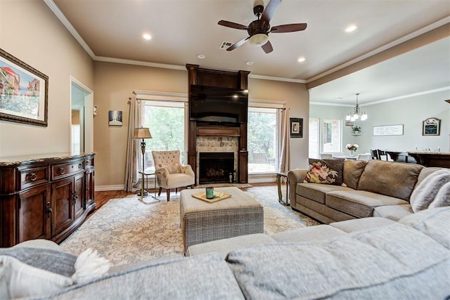 living room with visible vents, a large fireplace, baseboards, ornamental molding, and light wood-style floors