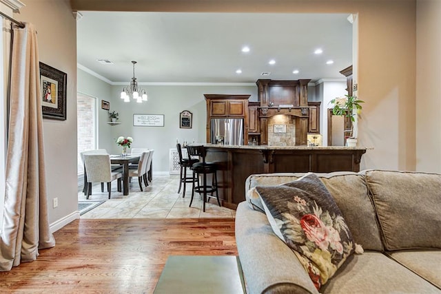 living room with light hardwood / wood-style flooring, a chandelier, and ornamental molding