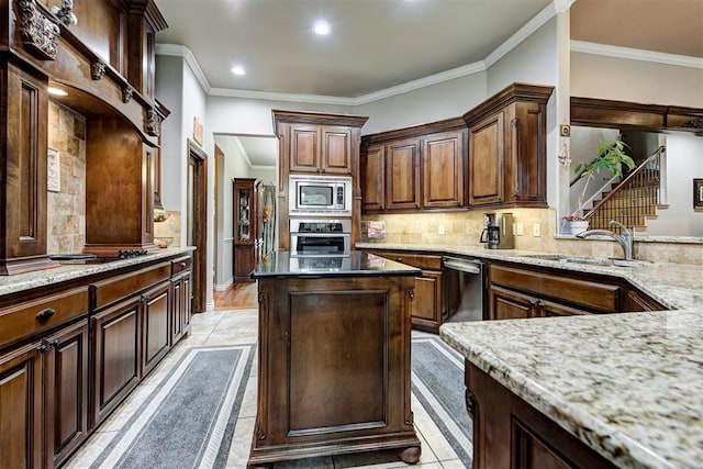 kitchen with light stone counters, crown molding, stainless steel appliances, and sink