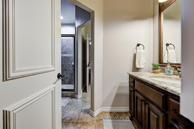 bathroom with tile patterned flooring, vanity, and a tile shower