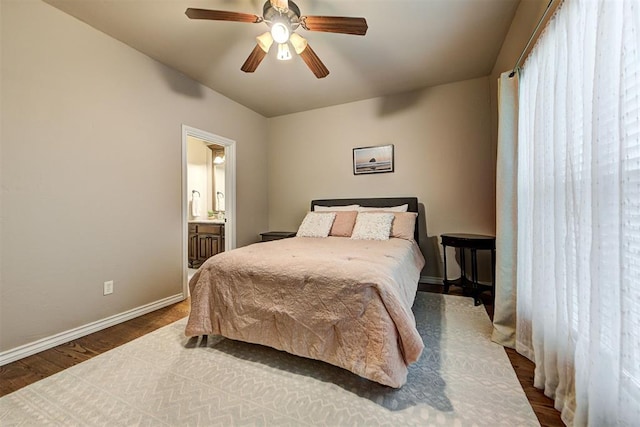 bedroom featuring dark hardwood / wood-style floors, ensuite bath, and ceiling fan