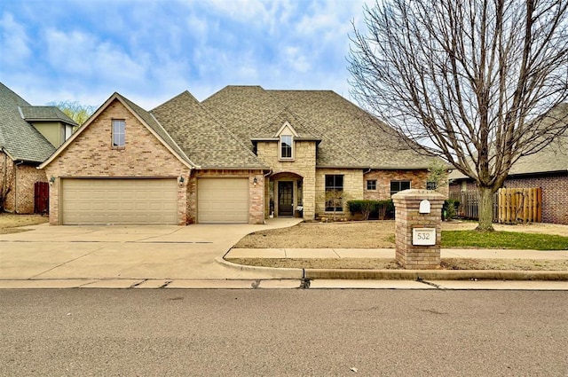 view of front of house featuring brick siding, fence, roof with shingles, a garage, and driveway