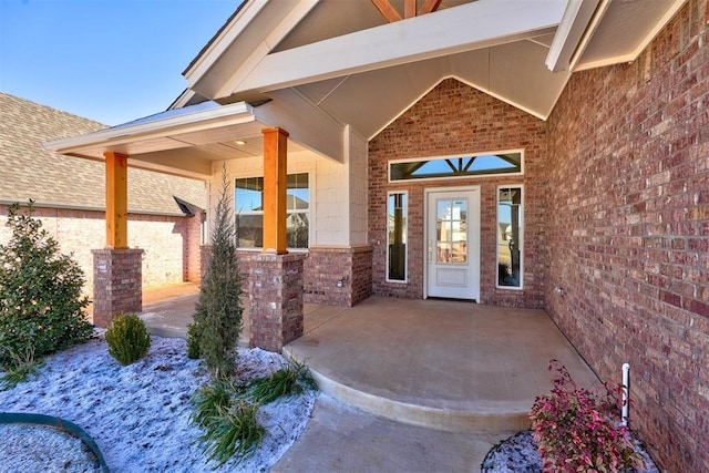 view of exterior entry with a patio