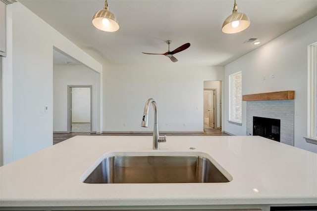 kitchen with decorative light fixtures, sink, and ceiling fan