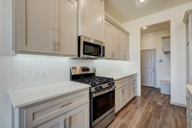 kitchen featuring dark wood-type flooring, backsplash, and stainless steel appliances