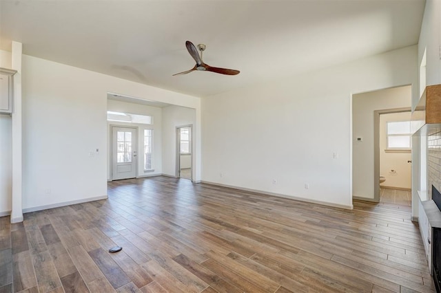 unfurnished living room featuring ceiling fan and light wood-type flooring