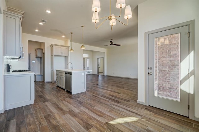 kitchen with hardwood / wood-style floors, decorative light fixtures, white cabinetry, an island with sink, and stainless steel dishwasher