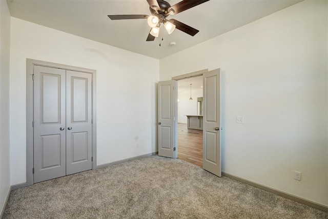 unfurnished bedroom with light colored carpet, a closet, and ceiling fan