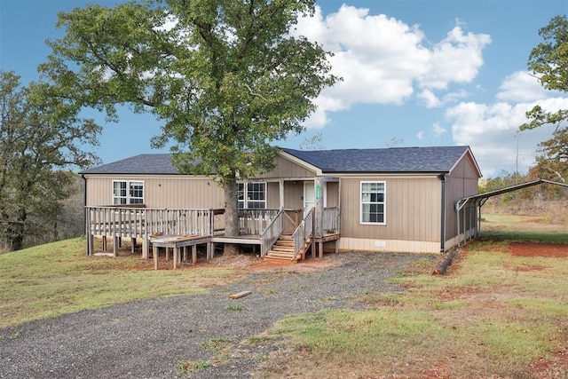 view of front of house featuring a front yard, a carport, and a wooden deck