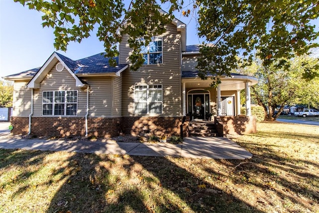 view of front of house featuring a front lawn and covered porch